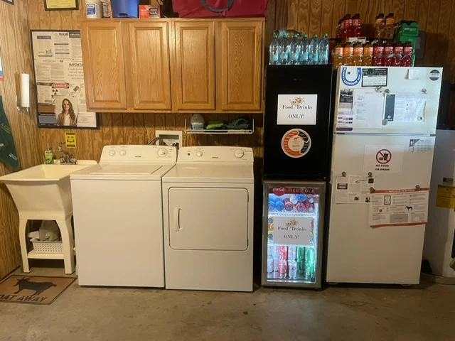 Apartment includes kitchen sink, washer, dryer, cabinets, and several refrigerators