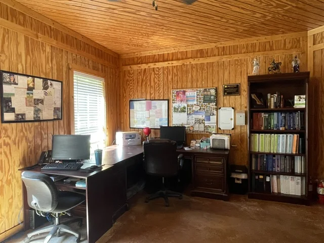 Office space with bookshelf, desks, and computers